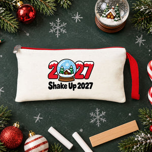 Cream pencil case with a red zipper and a Shake Up 2027 snow globe print on a school chalkboard with coloured pencils, chalk and candy canes