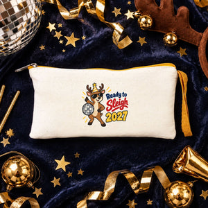Cream zipper pouch with a yellow zipper and a Ready to Sleigh 2027 disco reindeer print on navy velvet with a disco ball, sparklers and gold confetti