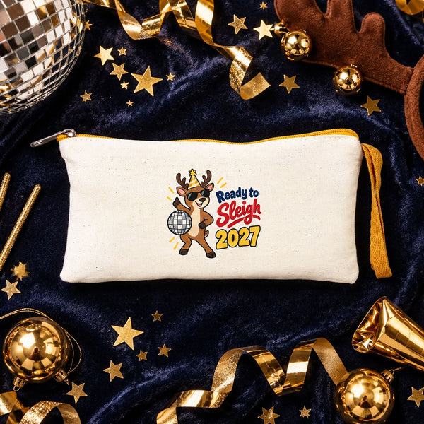 Cream zipper pouch with a yellow zipper and a Ready to Sleigh 2027 disco reindeer print on navy velvet with a disco ball, sparklers and gold confetti
