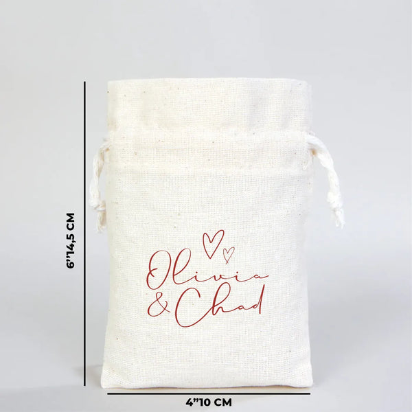 White drawstring bag with 'Olivia & Chad' text and measurements on a gray background