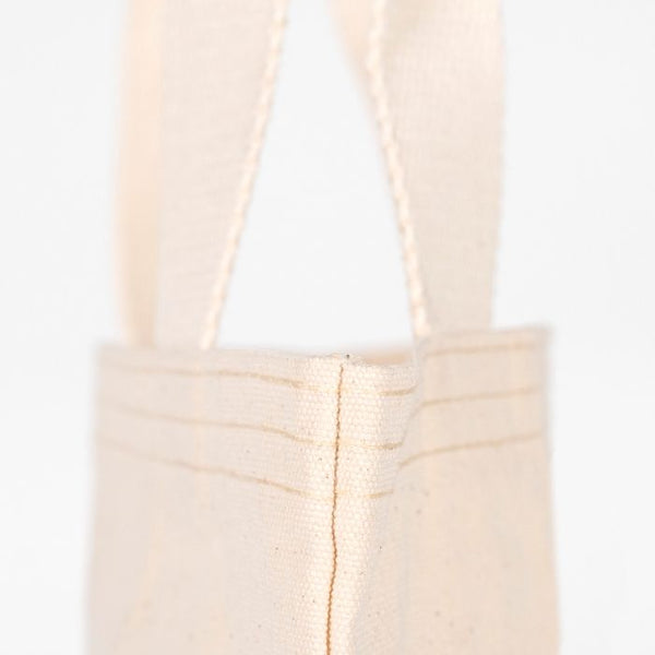 Beige tote bag with handles on a white background