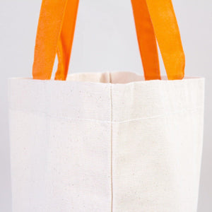 White tote bag with orange handles on a light gray background