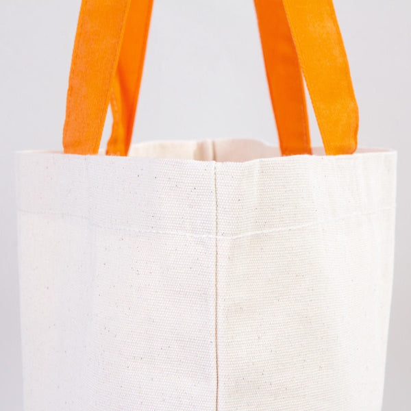 White tote bag with orange handles on a light gray background