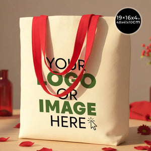 Beige tote bag with red handles and customizable text area on a wooden surface.