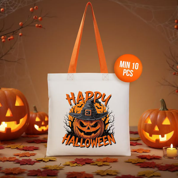 White tote bag with 'Happy Halloween' design featuring a pumpkin and witch hat, surrounded by Halloween decorations.