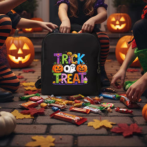 Black trick-or-treat bag with colorful text surrounded by Halloween candy and pumpkins.