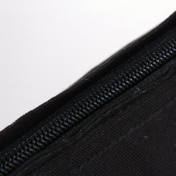 Close-up of a black zipper on a textured surface with a white background